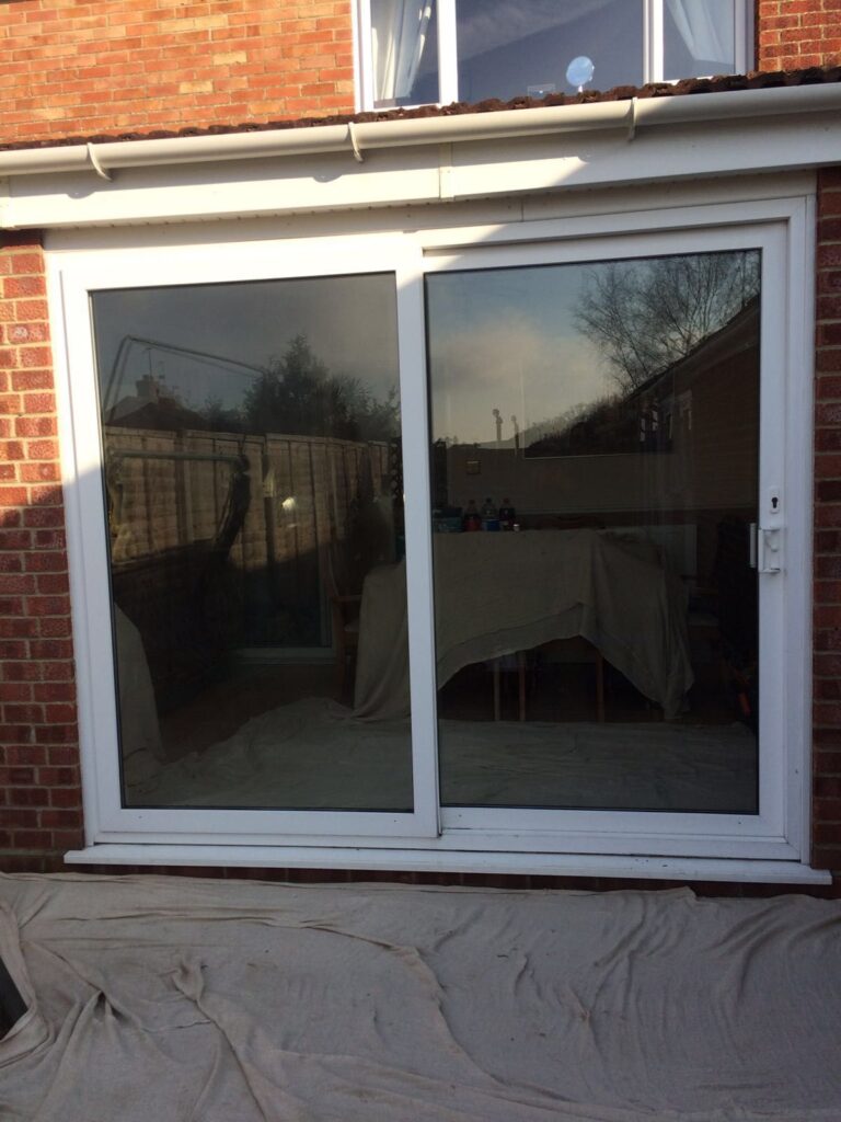 Closed white sliding doors in front of a stone patio