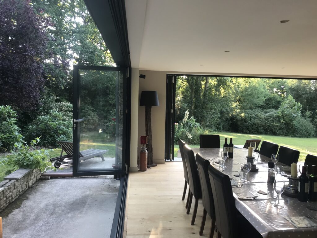 side view of folded open bifold doors next to a dining room