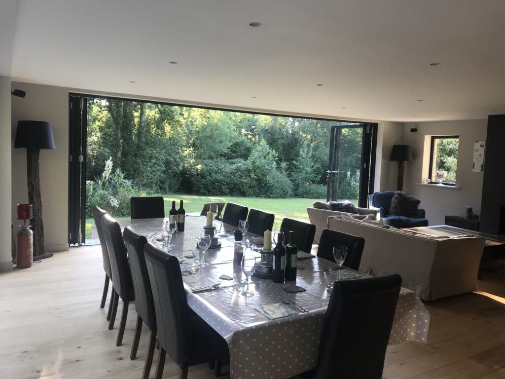 dining room with open bifold doors behind table and chairs