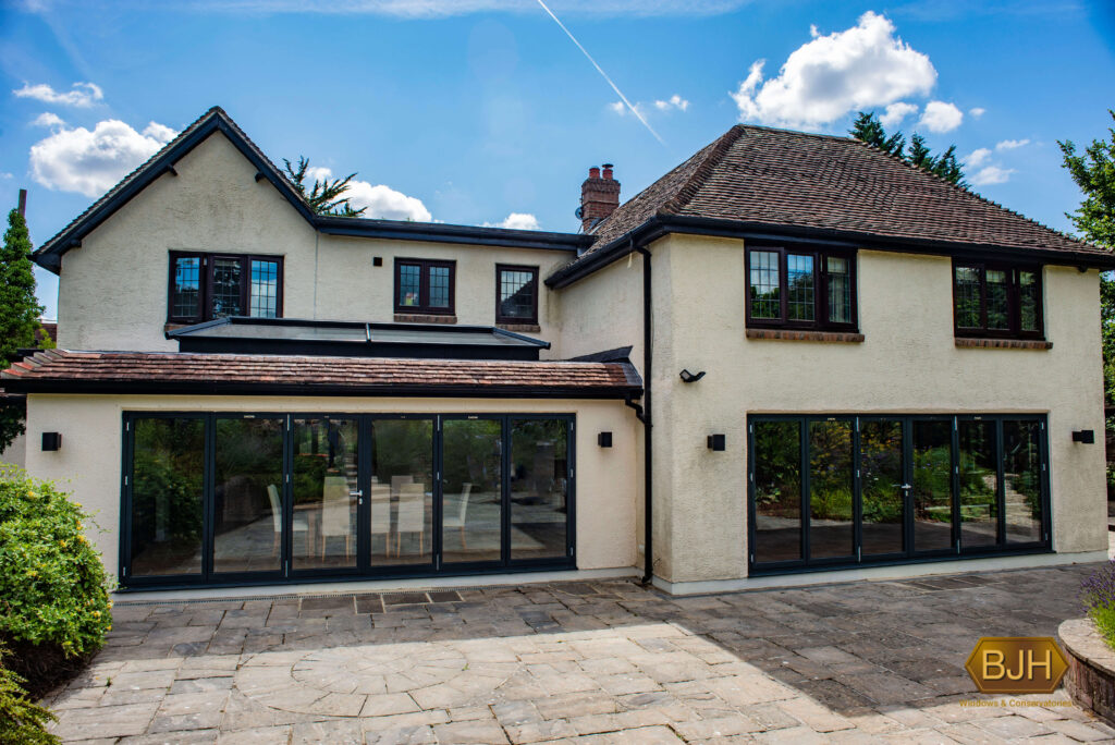 closed grey bifold doors on a white house driveway