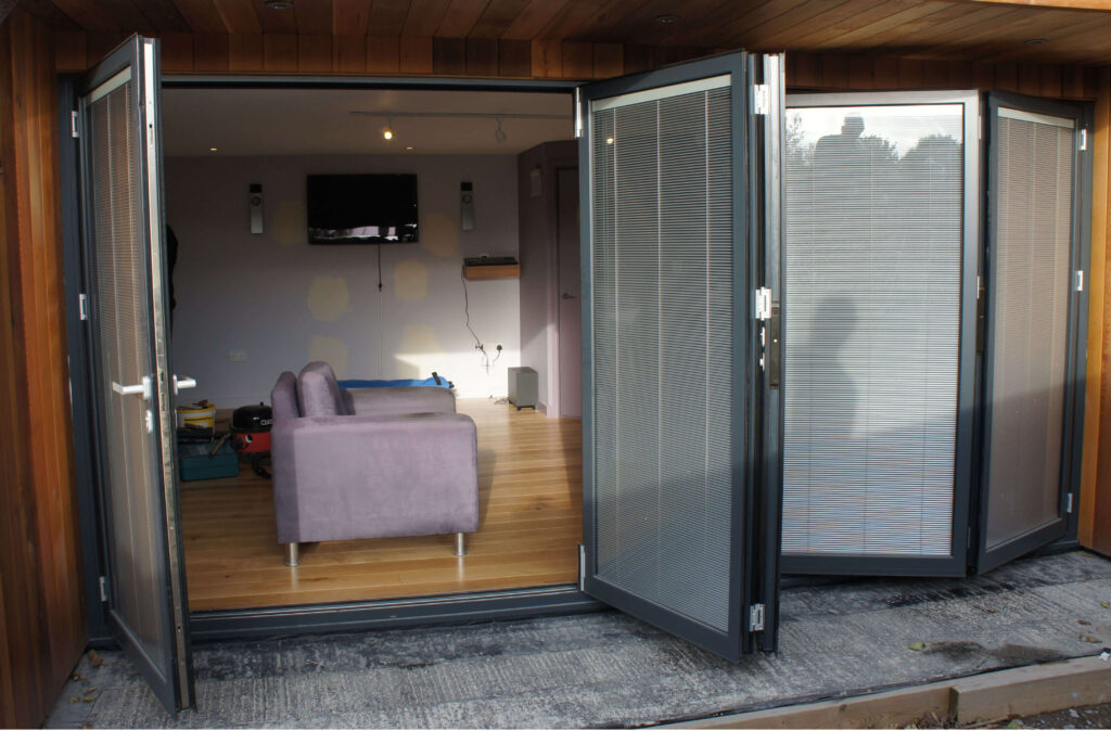 Open grey aluminium bifold doors leading to living room