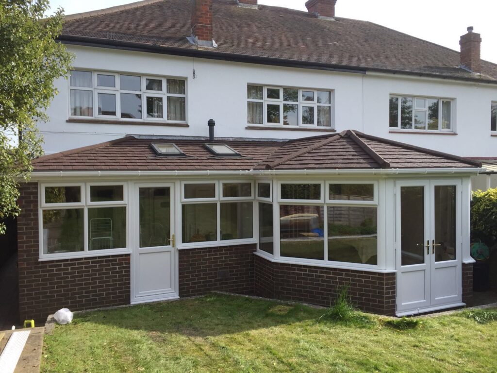 conservatory made from brick and glass with white frames as well as two small windows on the roof of the conservatory
