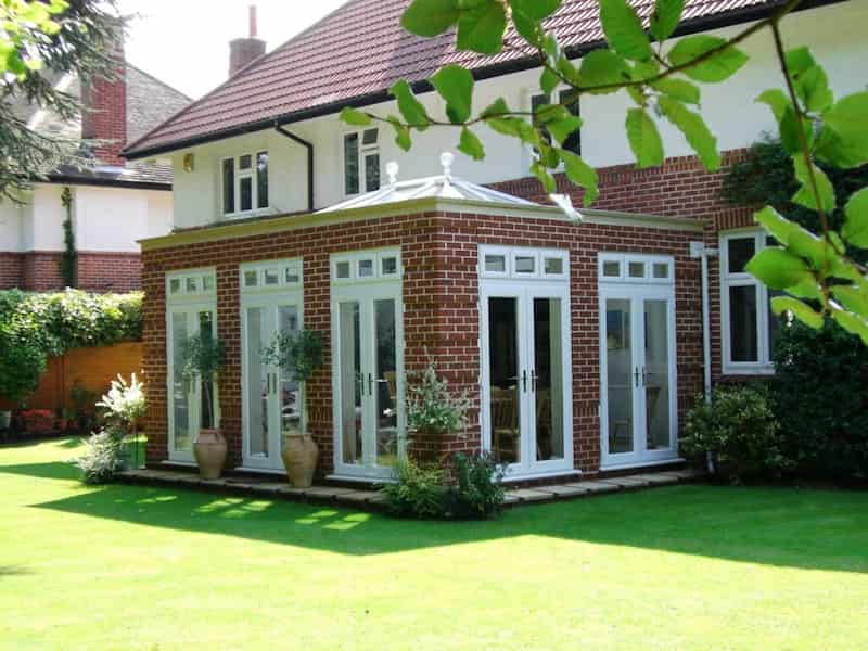 conservatory made out of brick and glass doors with white frames